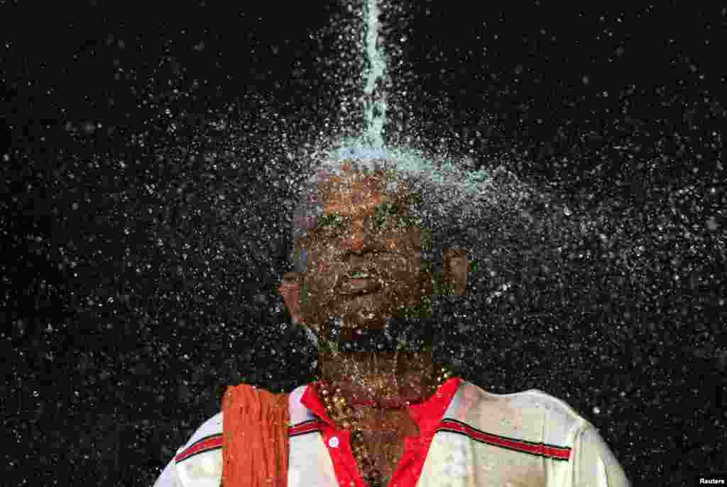 A Hindu devotee takes a ritual shower before he starts his pilgrimage to the sacred Batu Caves Temple during Thaipusam festival outside Kuala Lumpur, Malaysia. Thousands of Hindus participate in the annual thanksgiving festival in which devotees subject themselves to painful rituals in a demonstration of faith and penance held in honor of Lord Subramaniam.