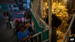 Habitantes del distrito Catia, en Caracas, esperan para recibir las bolsas de comida subsidiada por el gobierno, conocidas como CLAP, el 31 de enero de 2019. 