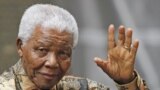 FILE - Former South African President Nelson Mandela waves to the media as he arrives outside 10 Downing Street, in central London, 28 August 2007. 