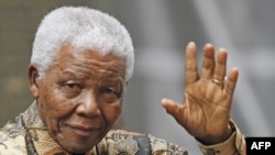 FILE - Former South African President Nelson Mandela waves to the media as he arrives outside 10 Downing Street, in central London, 28 August 2007. 