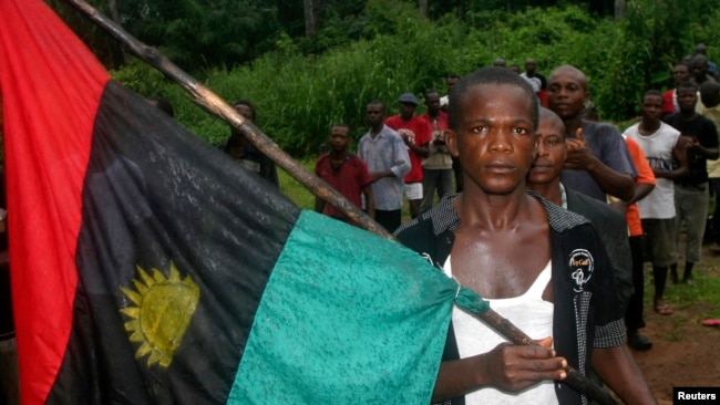 FILE - A man carries the Biafran flag during a parade in Ekwe village, near Enugu, southeastern Nigeria.