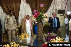 U.S. Charge d'Affaires to Sudan Steven Koutsis (right, in suit) snaps his fingers to music as guests gather for a dinner honoring militia commander Mohamed Hamdan Dagolo (far left). Also pictured is Saudi Ambassador to Sudan Sheikh Abdullah al Malhouk.