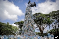 FILE - A giant art sculpture showing a tap outpouring plastic bottles, each of which was picked up in the neighborhood of Kibera, during the U.N. Environment Assembly (UNEA) held at the U.N. Environment Programme (UNEP) headquarters in Nairobi. (AP Photo/Brian Inganga, File)