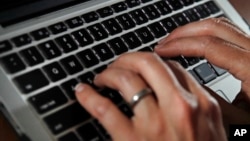 FILE- In this June 19, 2017, photo, a person types on a laptop keyboard.