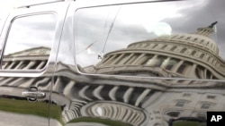 Bayangan gedung Capitol pada sebuah mobil yang diparkir di pelataran gedung di Washington, DC (28/9).