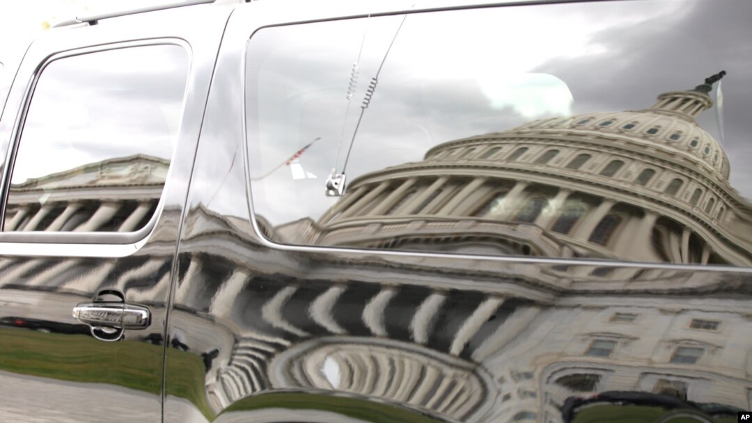 Bayangan gedung Capitol pada sebuah mobil yang diparkir di pelataran gedung di Washington, DC (28/9).