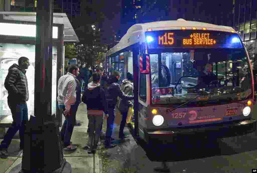 This photo provided by Metropolitan Transportation Authority shows people boarding a bus, as partial bus service was restored on Oct. 30, 2012.