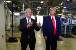 Apple CEO'su Tim Cook, Kasım 2019'da Apple fabrikası ziyareti sırasında Başkan Trump'a eşlik ederken