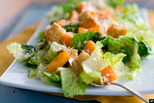 FILE - This Jan. 24, 2012, file photo shows a plate of butternut Caesar salad with Romaine lettuce and roasted cubes of butternut squash. (AP Photo/Matthew Mead, File)