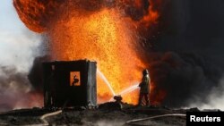 Firefighters and engineers battle fires at oil wells set ablaze by Islamic State militants before fleeing the oil-producing region of Qayyara, Iraq, Jan. 18, 2017. 
