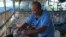FILE - Eel farm owner Em Phat, 53, works in Tonle Sap complex, north of Phnom Penh Cambodia, July 31, 2024.