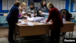 Члены избирательной комиссии ведут подсчет глосов избирателей на однои из избирательных пунктов. Кишинев, Молдова. 30 ноября 2014 г.