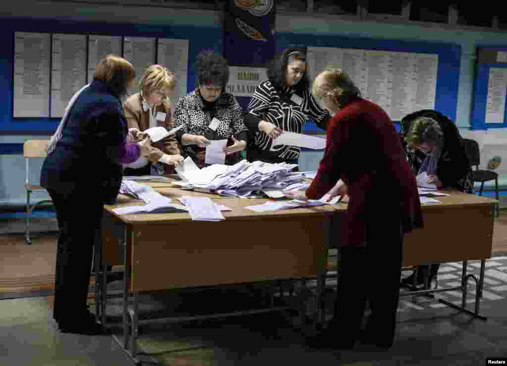 Members of a local electoral commission count ballots after a parliamentary election, at a polling station in Chisinau, Moldova, Nov. 30, 2014.