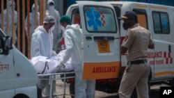 Petugas medis membawa seorang pasien yang meninggal karena COVID-19 di rumah sakit di Mumbai, India (foto: ilustrasi).