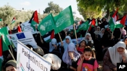 FILE - Hamas supporters protest against Israel's plan to annex parts of the West Bank and US President Donald Trump's Mideast initiative, at the Palestinian side of Erez checkpoint between Israel and Gaza, in Beit Hanoun, Gaza Strip, July 9, 2020.