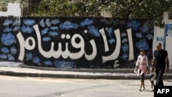 Un Palestinien et sa fille passent devant un mur où l'on peut lire «Division» à Gaza le 17 septembre 2017.