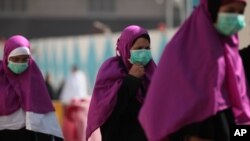 Muslim pilgrims wears surgical masks to help prevent infection from a respiratory virus known as the Middle East Respiratory Syndrome (MERS) in the holy city of Mecca, Saudi Arabia, May 13, 2014.