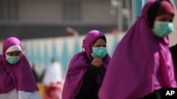 Muslim pilgrims wears surgical masks to help prevent infection from a respiratory virus known as the Middle East Respiratory Syndrome (MERS) in the holy city of Mecca, Saudi Arabia, May, 13, 2014.