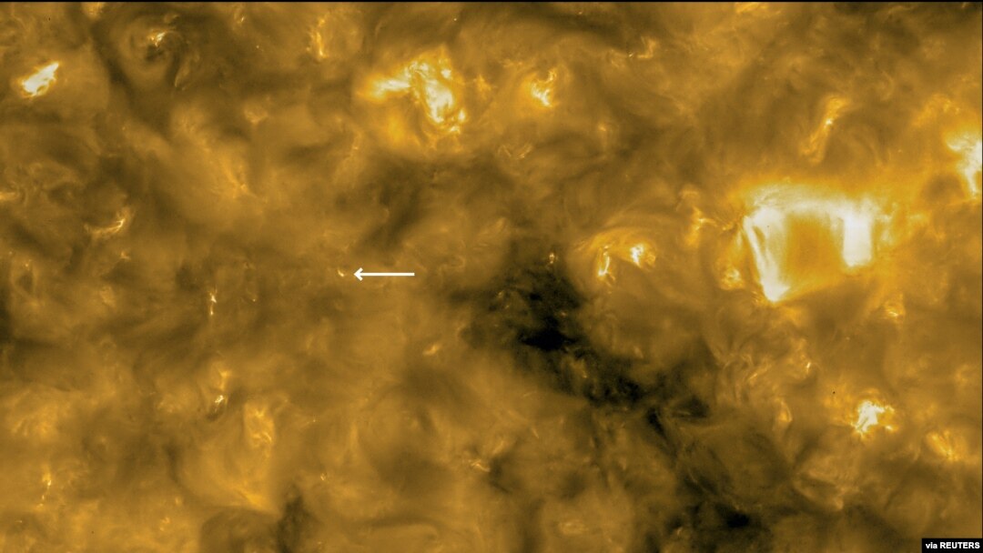 This image of the sun from NASA/ESA's Solar Orbiter spacecraft was taken May 30, 2020, and released by ESA July 16, 2020. The circle at lower left indicates the size of the Earth for scale. The arrow points to a solar surface "campfire."