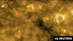 This image of the sun from NASA/ESA's Solar Orbiter spacecraft was taken May 30, 2020, and released by ESA July 16, 2020. The circle at lower left indicates the size of the Earth for scale. The arrow points to a solar surface "campfire."