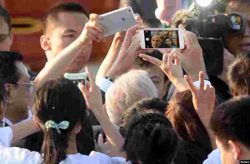 Perdana Menteri India Narendra Modi mengambil selfie dengan ponsel bersama perfomer acara Taiji dan Yoga di taman Kuil Nirwana di Beijing, China.