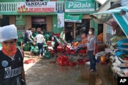 Residentes ordenan cajas de botellas de refresco después del fuerte terremoto en Cataingan, provincia de Masbate, en el centro de Filipinas, el martes 18 de agosto de 2020.