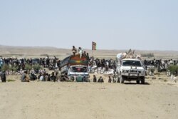 FILE - Afghan traders and citizens gather near Pakistan's Badini Trade Terminal Gateway, a border crossing point between Pakistan and Afghanistan, at Qila Saifullah, Balochistan province, Sept. 16, 2020.