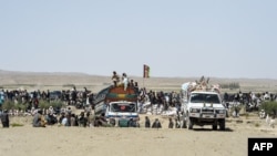 FILE - Afghan traders and citizens gather near Pakistan's Badini Trade Terminal Gateway, a border crossing point between Pakistan and Afghanistan, at the country's border town of Qila Saifullah in the southwestern province of Balochistan, Sept. 16, 2020.
