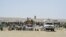 FILE - Afghan traders and citizens gather near Pakistan's Badini Trade Terminal Gateway, a border crossing point between Pakistan and Afghanistan, at the country's border town of Qila Saifullah in the southwestern province of Balochistan, Sept. 16, 2020.