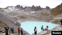 People look at the Pizol glacier as they take part in a mourning ceremony .as awareness to climate change, Switzerland, Sept. 22, 2019