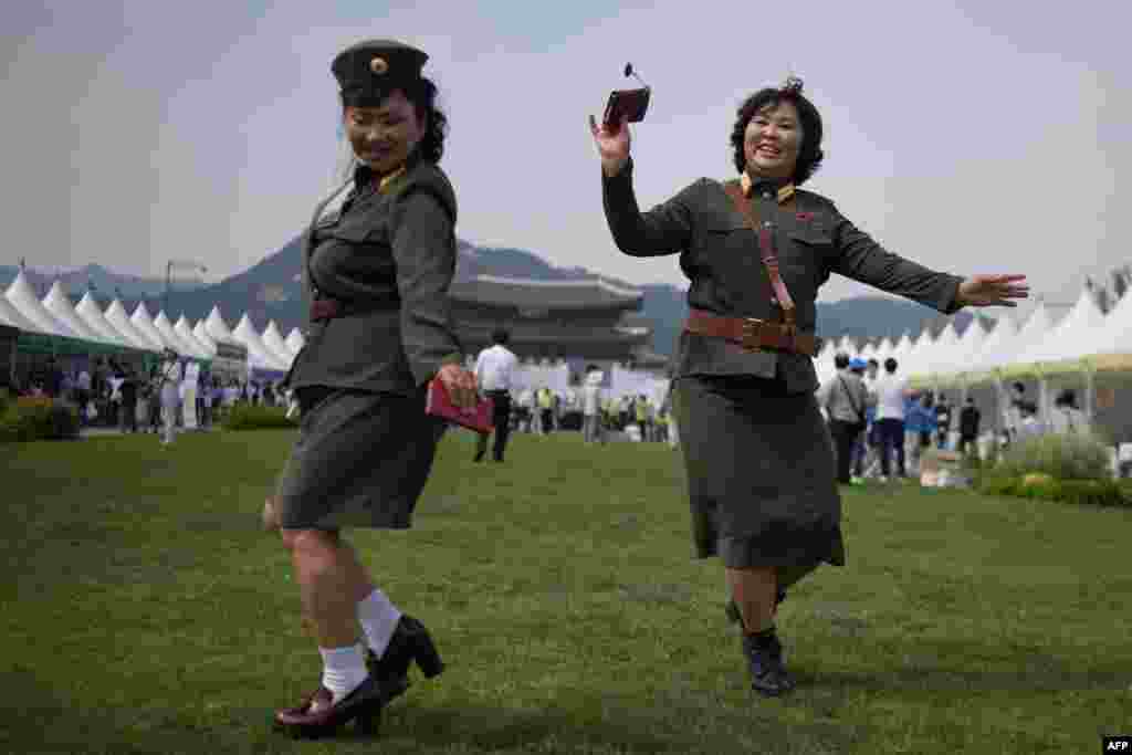 North Korean defectors wearing North Korean military uniforms dance in Gwanghwamun square during a &#39;unification expo&#39; in central Seoul, South Korea. The expo aims to raise awareness about inter-Korean unification.