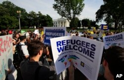 FILE - Refugees and community activists gather in front of the White House in Washington, June 20, 2017, during a rally in solidarity with refugees to commemorate World Refugee Day.