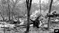 ARCHIVES – Sur cette photo de 19 septembre 1961, des investigateurs examinent les débris épars de l'avion DC6B qui transportait Dag Hammarskjold et qui s’est écrasé dans une forêt près de Ndola, en Zambie, dans des conditions qui n’ont jamais été élucidées. 