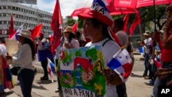 Una mujer sostiene una pancarta con un mensaje que dice en español: "Amo Panamá, no la minería", durante una protesta contra un contrato minero entre el gobierno panameño y la minera canadiense First Quantum, en Ciudad de Panamá, el viernes 3 de noviembre.