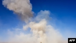 FILE - Smoke rises from the site of an attack in Feroz Koh, the capital of Ghor province, Oct. 18, 2020. An Afghan journalist was shot and killed by unidentified gunmen in the area on Jan. 1, 2021.