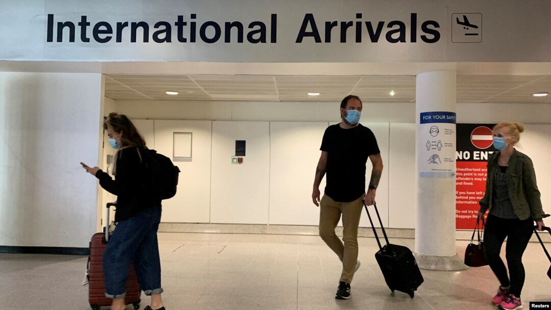 Passengers are seen wearing face coverings after arriving at Manchester Airport following the outbreak of the coronavirus disease (COVID-19) in Manchester, Britain, July 26, 2020. 