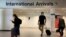 Passengers are seen wearing face coverings after arriving at Manchester Airport following the outbreak of the coronavirus disease (COVID-19) in Manchester, Britain, July 26, 2020. 