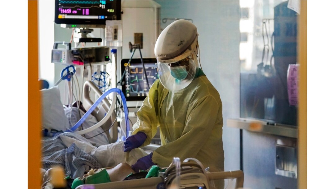 FILE - A health care worker tends to a COVID-19 patient in the intensive care unit at Santa Clara Valley Medical Center during the coronavirus pandemic in San Jose, California, January 13, 2021.
