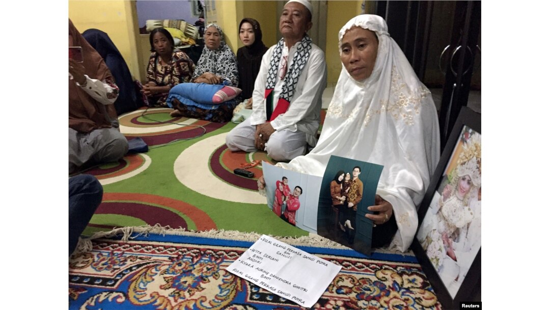 Susmawati, guru sekolah dasar di kediamannya di Pangkal Pinang, menunjukkan foto putrinya, Wita Seriani dan keluarganya, yang menjadi korban kecelakaan pesawat Lion Air JT610, 31 Oktober 2018.(Foto: Reuters)