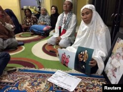 Susmawati, guru sekolah dasar di kediamannya di Pangkal Pinang, menunjukkan foto putrinya, Wita Seriani dan keluarganya, yang menjadi korban kecelakaan pesawat Lion Air JT610, 31 Oktober 2018.(Foto: Reuters)