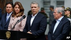 Colombia's President Ivan Duque gives a statement inside the General Santander police academy after a bomb exploded on the campus in Bogota, Jan. 17, 2019. At right is Defense Minister Guillermo Botero and at left is Vice President Martha Lucia Ramirez.