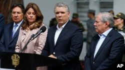 Colombia's President Ivan Duque gives a statement inside the General Santander police academy after a bomb exploded on the campus in Bogota, Jan. 17, 2019. At right is Defense Minister Guillermo Botero and at left is Vice President Martha Lucia Ramirez. 