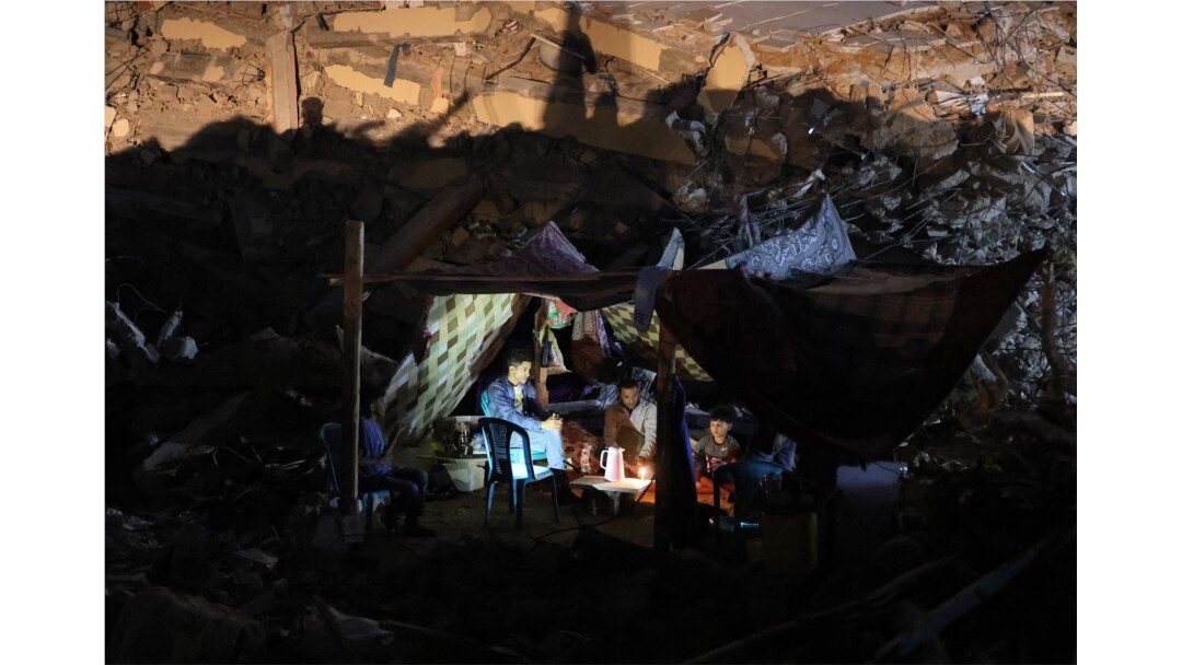 Warga Palestina duduk di tenda yang telah didirikan di atas reruntuhan bangunan yang hancur akibat serangan udara Israel baru-baru ini, di Kota Gaza, pada 24 Mei 2021. (Foto: AFP)