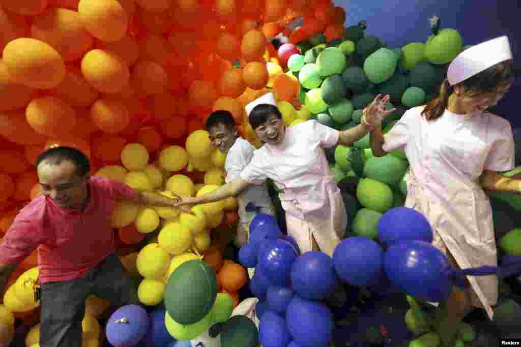 Participants walk among balloons during a stress-relief event organized by a shopping mall in Dongguan, Guangdong province, China.