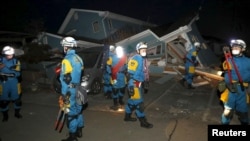2016年4月16日日本警方人员查看熊本县震后倒塌房屋