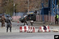 FILE - Security forces inspect the site of a deadly blast near a demonstration by hundreds of minority Shi'ites, in the center of Kabul, Afghanistan, Nov. 12, 2018. Afghan officials confirmed several people were killed in the explosion about 500 meters (yards) from where people gathered to denounce Taliban attacks in Jaghuri and Malistan districts of eastern Ghazni province.