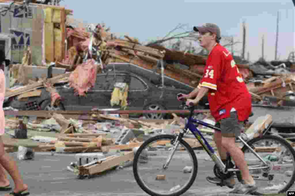 Onlookers make their way through the rubble left by a strong tornado Wednesday, April 27, 2011 Tuscaloosa, Ala. A wave of severe storms laced with tornadoes strafed the South on Wednesday, killing at least 16 people around the region and splintering build