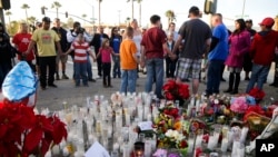 People pray at a makeshift memorial to honor the victims of Wednesday's shooting rampage, Dec. 5, 2015, in San Bernardino, Calif. 