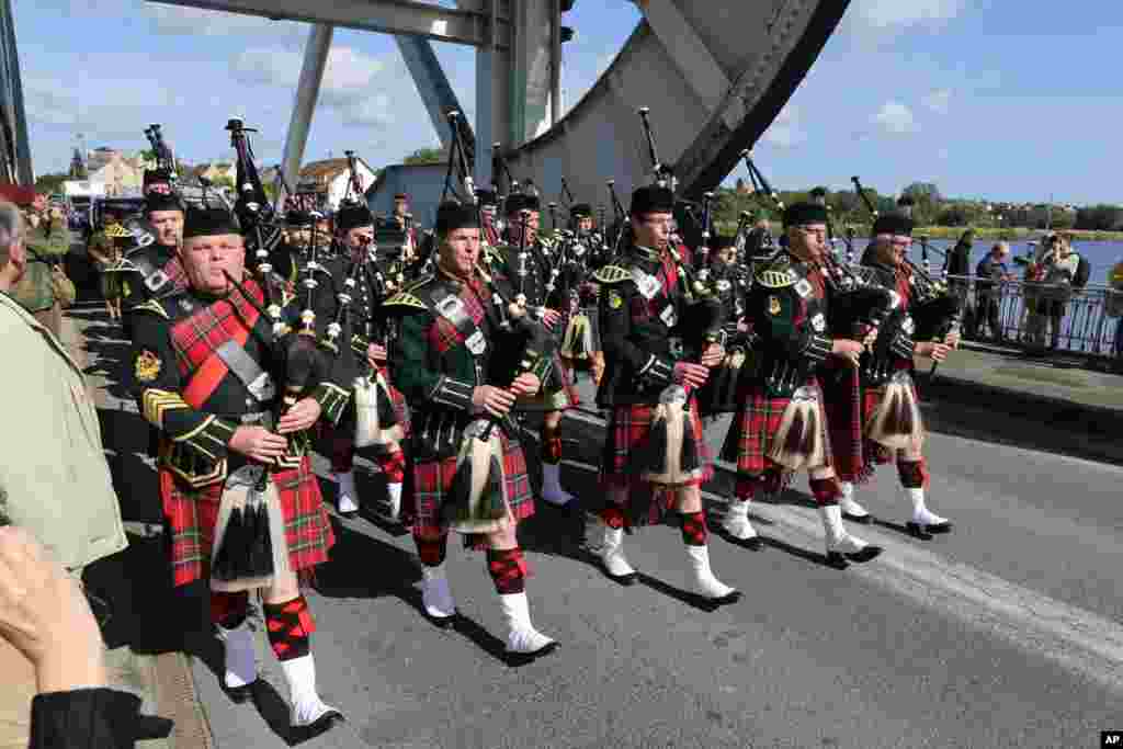 A Scottish pipe band parades on Pegasus Bridge in Benouville, France, as part of the commemoration of the 70th anniversary of D-Day, June 5, 2014.