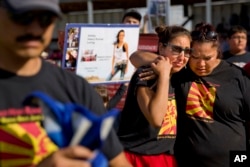 Jenna Loring, left, the aunt of Ashley HeavyRunner Loring, cries with her cousin, Lissa Loring, during a traditional blanket dance before the crowd at the North American Indian Days celebration on the Blackfeet Indian Reservation in Browning, Mont., July 14, 2018. The "dance" was held to raise awareness and funds for the search for Ashley, who has been missing since June 2017.